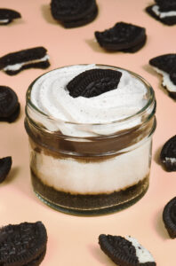 alt="Oreo cheesecake jar with an Oreo cookie crust, creamy Oreo cheesecake with cookie bits, layered with cookie butter crunch and topped with Oreo cream and cookie — made from scratch in San Antonio, Texas"