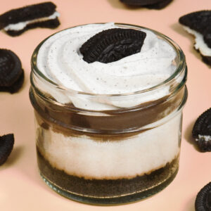 alt="Oreo cheesecake jar with an Oreo cookie crust, creamy Oreo cheesecake with cookie bits, layered with cookie butter crunch and topped with Oreo cream and cookie — made from scratch in San Antonio, Texas"