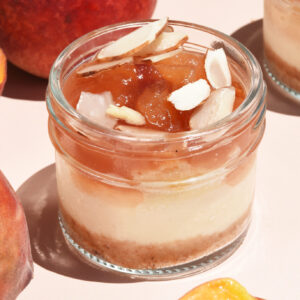 alt="Silky Vanilla Cheesecake layered with Baked Almond Cream. Finished with Peach Jam made from fresh peaches and a sprinkle of Toasted Almond Petals. Perfect fruity and fresh summer flavor. Made from scratch in San Antonio Texas"