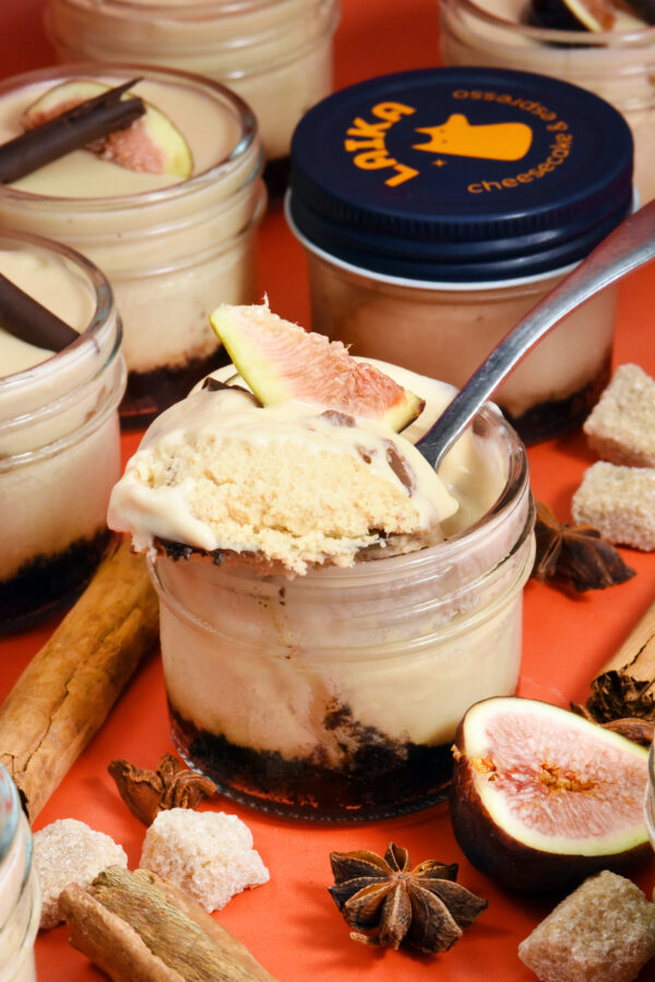 alt="Layered cheesecake jar made from scratch in San Antonio — starting with an Oreo crust, chai cheesecake, butterscotch crunch, silky butterscotch mousse, topped with fresh fig and a dark chocolate cigarette."