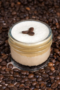 Espresso Martini Cheesecake in a Jar made in San Antonio, Texas, featuring Espresso Cream Foam, Espresso Martini Mousse, Milk Chocolate Cheesecake, and an Oreo Crust.