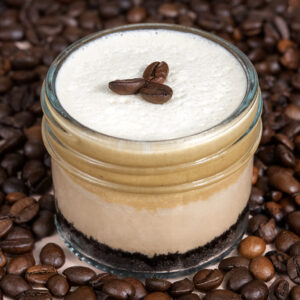Espresso Martini Cheesecake in a Jar made in San Antonio, Texas, featuring Espresso Cream Foam, Espresso Martini Mousse, Milk Chocolate Cheesecake, and an Oreo Crust.