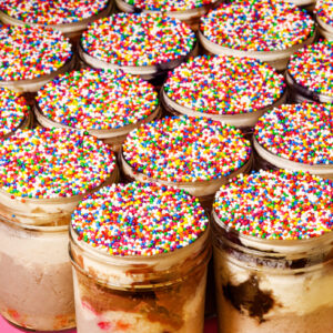 Viral Dot Cake Cheesecake: a layered cheesecake dessert with vanilla, chocolate, and cookies and cream cheesecake, birthday cake, chocolate cake, vanilla cream cheese buttercream, and a crunchy sprinkle shell made from scratch in San Antoni, Texas